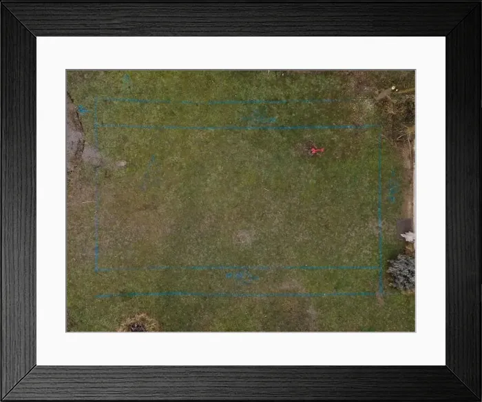 Framed Print : aerial drone shot of small, yellow excavator stands in a large garden and digs a hole for a pool in austria