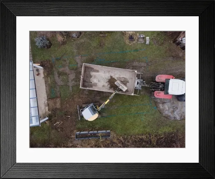 Framed Print : aerial drone shot of small, yellow excavator stands in a large garden and digs a hole for a pool in austria Framed Print : aerial drone shot of small, yellow excavator stands in a large garden and digs a hole for a pool in austria