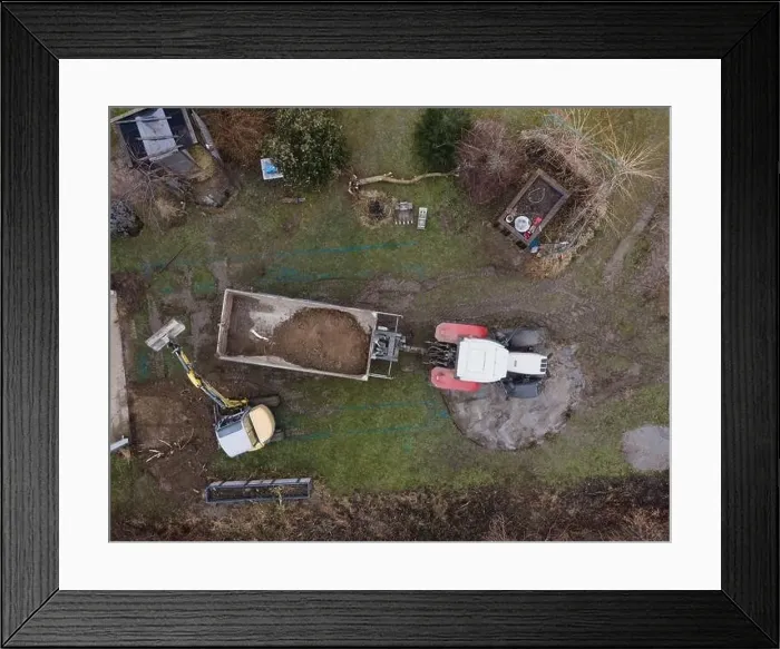 Framed Print : aerial drone shot of small, yellow excavator stands in a large garden and digs a hole for a pool in austria Framed Print : aerial drone shot of small, yellow excavator stands in a large garden and digs a hole for a pool in austria