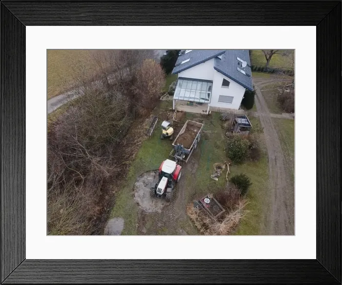 Framed Print : aerial drone shot of small, yellow excavator stands in a large garden and digs a hole for a pool in austria Framed Print : aerial drone shot of small, yellow excavator stands in a large garden and digs a hole for a pool in austria