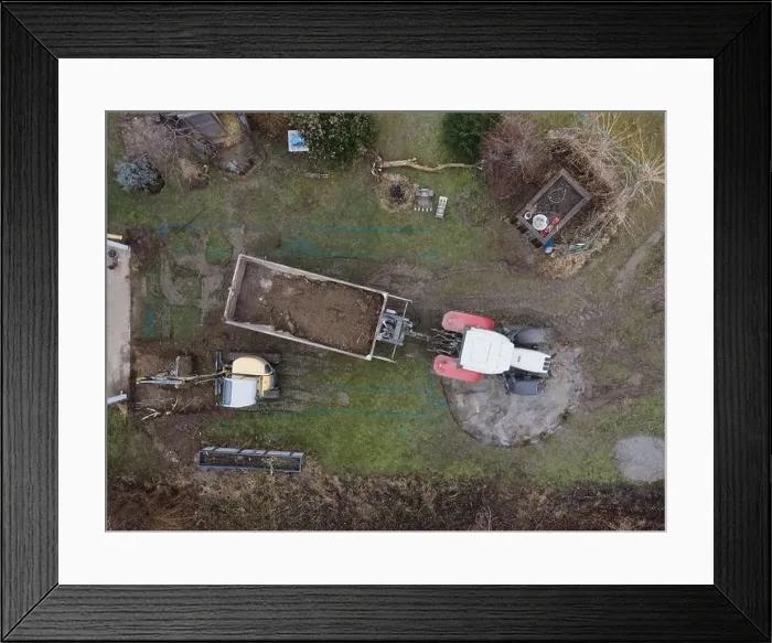 Framed Print : aerial drone shot of small, yellow excavator stands in a large garden and digs a hole for a pool in austria Framed Print : aerial drone shot of small, yellow excavator stands in a large garden and digs a hole for a pool in austria