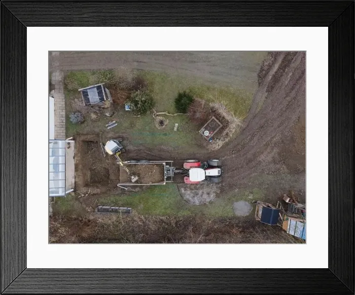 Framed Print : aerial drone shot of small, yellow excavator stands in a large garden and digs a hole for a pool in austria Framed Print : aerial drone shot of small, yellow excavator stands in a large garden and digs a hole for a pool in austria