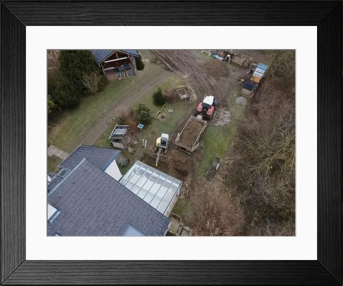 Framed Print : aerial drone shot of small, yellow excavator stands in a large garden and digs a hole for a pool in austria Framed Print : aerial drone shot of small, yellow excavator stands in a large garden and digs a hole for a pool in austria