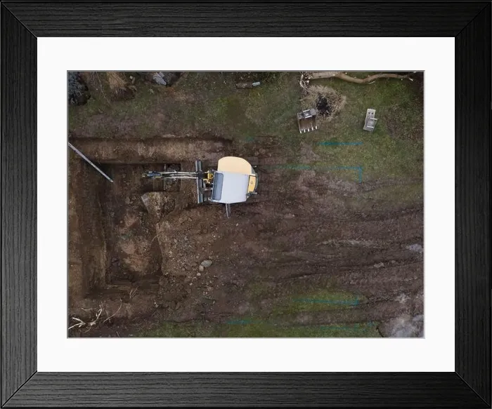 Framed Print : aerial drone shot of small, yellow excavator stands in a large garden and digs a hole for a pool in austria Framed Print : aerial drone shot of small, yellow excavator stands in a large garden and digs a hole for a pool in austria