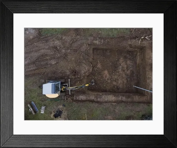 Framed Print : aerial drone shot of small, yellow excavator stands in a large garden and digs a hole for a pool in austria Framed Print : aerial drone shot of small, yellow excavator stands in a large garden and digs a hole for a pool in austria