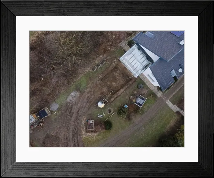 Framed Print : aerial drone shot of small, yellow excavator stands in a large garden and digs a hole for a pool in austria Framed Print : aerial drone shot of small, yellow excavator stands in a large garden and digs a hole for a pool in austria