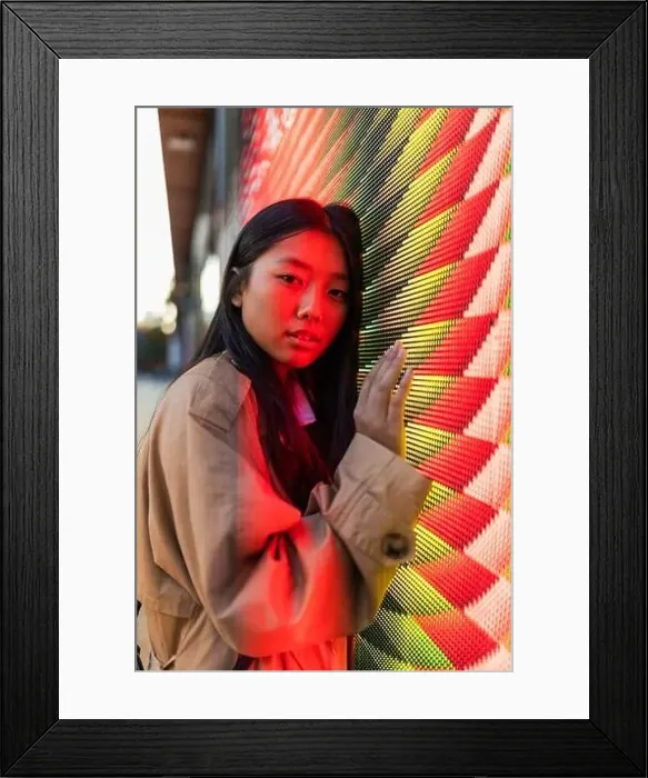 Framed Print : Wistful ethnic female in casual clothes with long hair looking at camera while leaning on wall with neon illumination Framed Print : Wistful ethnic female in casual clothes with long hair looking at camera while leaning on wall with neon illumination