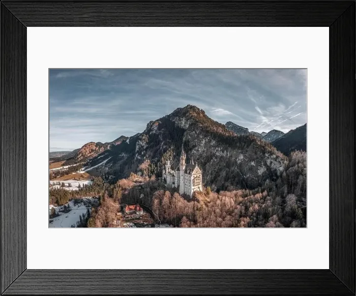Framed Print : Aerial drone shot of picturesque Neuschwanstein Castle on snowy hill in winter sunlight in Germany Framed Print : Aerial drone shot of picturesque Neuschwanstein Castle on snowy hill in winter sunlight in Germany