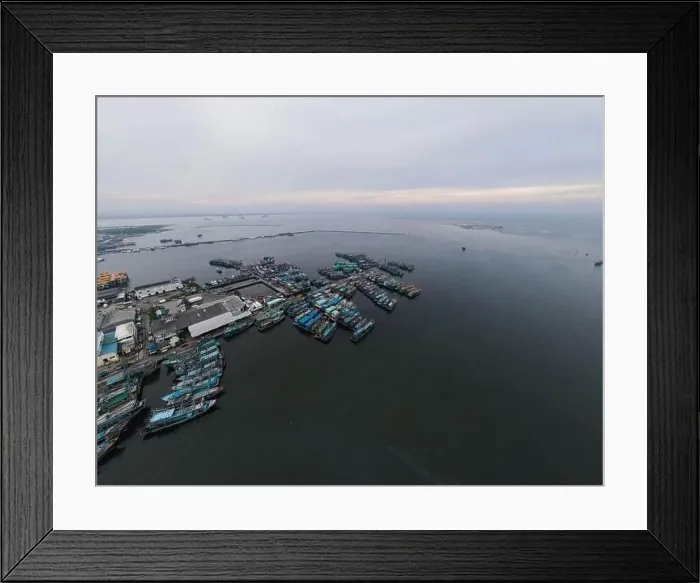 Framed Print : Aerial drone view of Muara Angke Beach with wooden boats leaning beside the pier Framed Print : Aerial drone view of Muara Angke Beach with wooden boats leaning beside the pier
