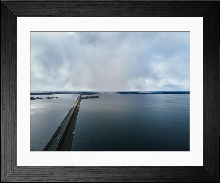Framed Print : Drone view of landscape of an asphalt road with cars going along the blue river Framed Print : Drone view of landscape of an asphalt road with cars going along the blue river