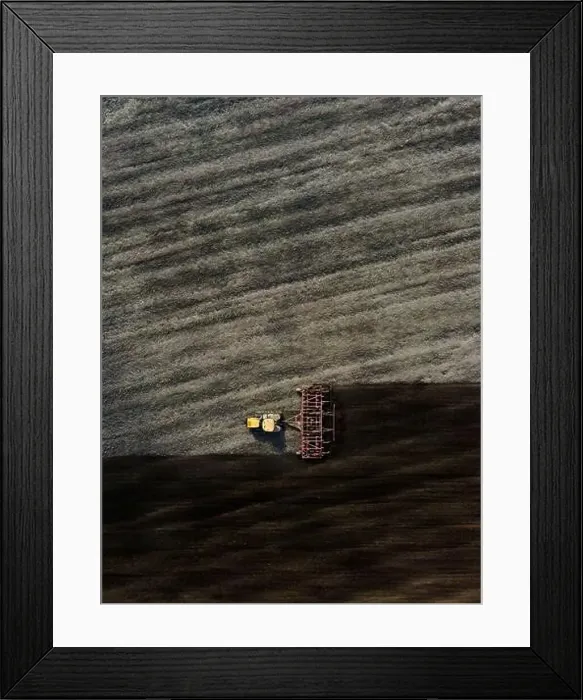 Framed Print : Aerial view of a modern yellow tractor plowing dry agricultural field Framed Print : Aerial view of a modern yellow tractor plowing dry agricultural field