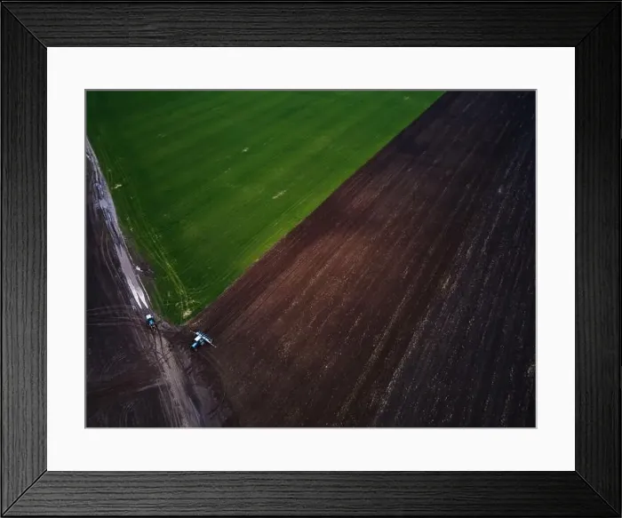 Framed Print : Aerial view of a modern green tractor plowing dry agricultural field Framed Print : Aerial view of a modern green tractor plowing dry agricultural field