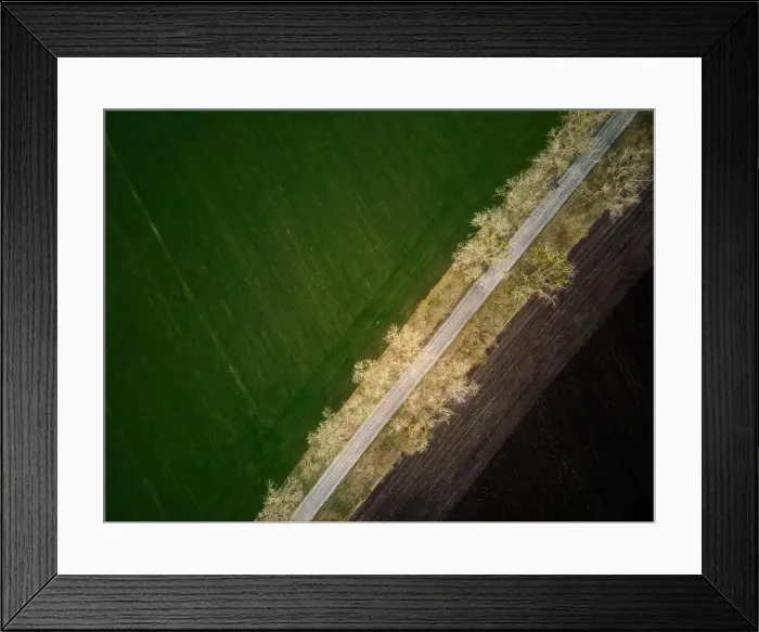 Framed Print : Aerial drone top view flight over ground land road and green field Framed Print : Aerial drone top view flight over ground land road and green field
