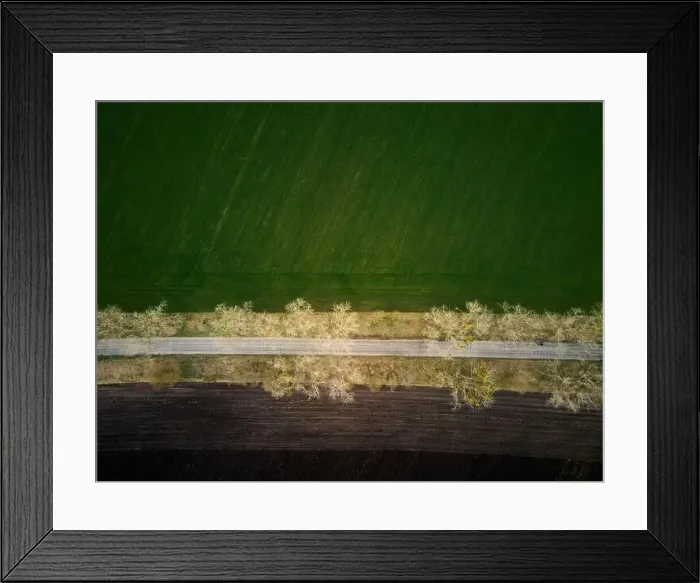 Framed Print : Aerial drone top view flight over ground land road and green field Framed Print : Aerial drone top view flight over ground land road and green field