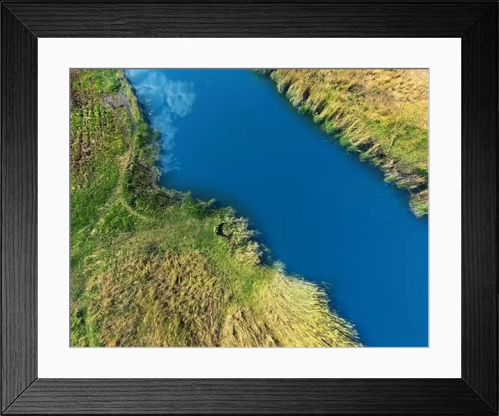Framed Print : Banks of the river are covered with greenery with a tourist lying on the bank. Shooting from a height Framed Print : Banks of the river are covered with greenery with a tourist lying on the bank. Shooting from a height