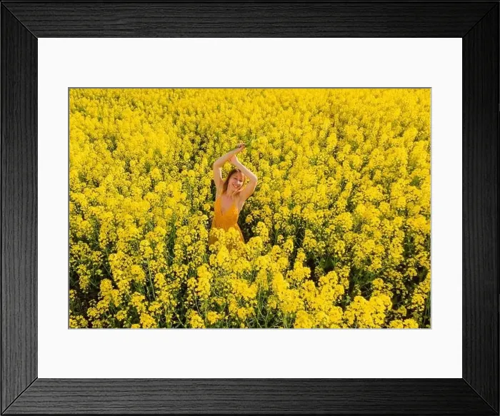 Framed Print : Aerial view of attractive woman at blooming rapeseed field. Yellow flowers and happy woman Framed Print : Aerial view of attractive woman at blooming rapeseed field. Yellow flowers and happy woman