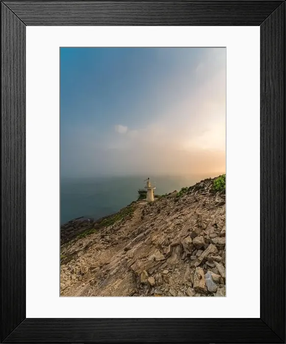 Framed Print : Sunrise by the sea with a lighthouse on the cliff