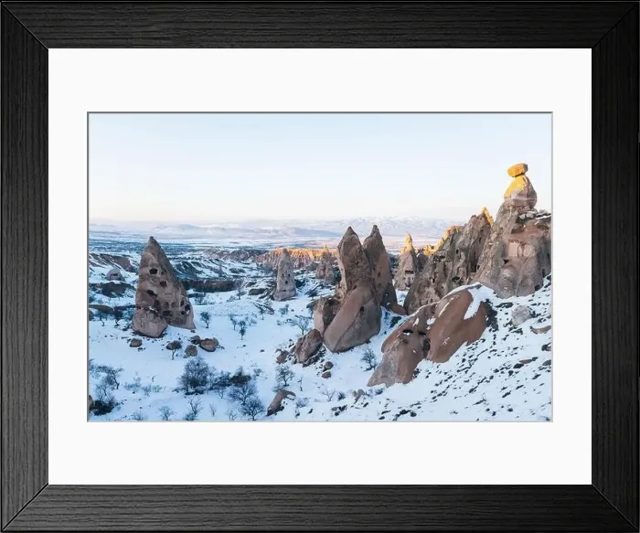 Framed Print : Aerial view of rough rock formations covered with white snow against cloudless evening sky in Cappadocia, Turkey Framed Print : Aerial view of rough rock formations covered with white snow against cloudless evening sky in Cappadocia, Turkey