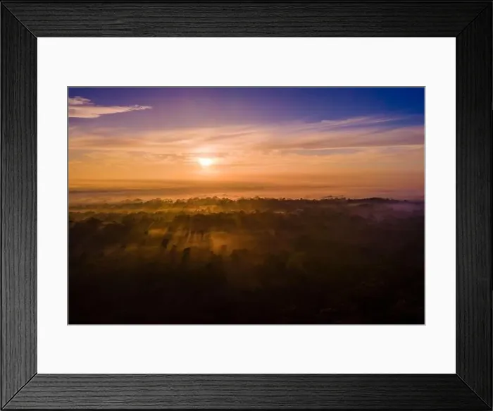 Framed Print : Sunrise shining golden rays through the early morning fog softly blanketing a prehistoric landscape Framed Print : Sunrise shining golden rays through the early morning fog softly blanketing a prehistoric landscape