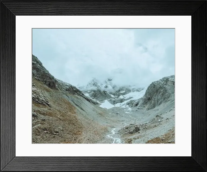 Framed Print : drone view over a desolate receding alpine glacier surrounded by mountains and snow covered rocks and peaks Framed Print : drone view over a desolate receding alpine glacier surrounded by mountains and snow covered rocks and peaks