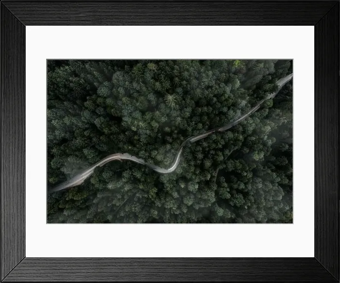 Framed Print : Winding curvy road inside a forest from a top down view of a drone at a foggy evening with a car backlight Framed Print : Winding curvy road inside a forest from a top down view of a drone at a foggy evening with a car backlight