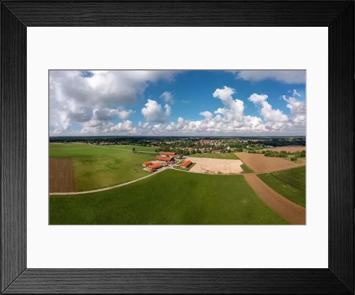 Framed Print : Aerial view over a ranch with horses and a village in the background under a blue, wonderful fluffy clouded sky Framed Print : Aerial view over a ranch with horses and a village in the background under a blue, wonderful fluffy clouded sky