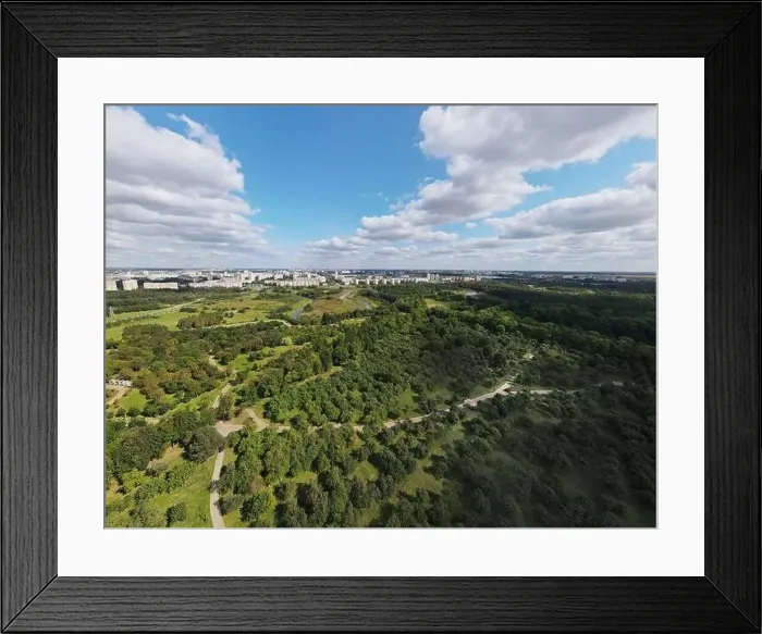 Framed Print : City landscape. Nearby there is a park area. Blue sky with white clouds. Aerial photography of the panorama Framed Print : City landscape. Nearby there is a park area. Blue sky with white clouds. Aerial photography of the panorama