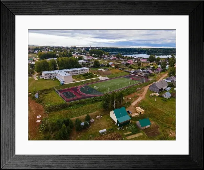 Framed Print : Houses and football field against river in suburb Framed Print : Houses and football field against river in suburb