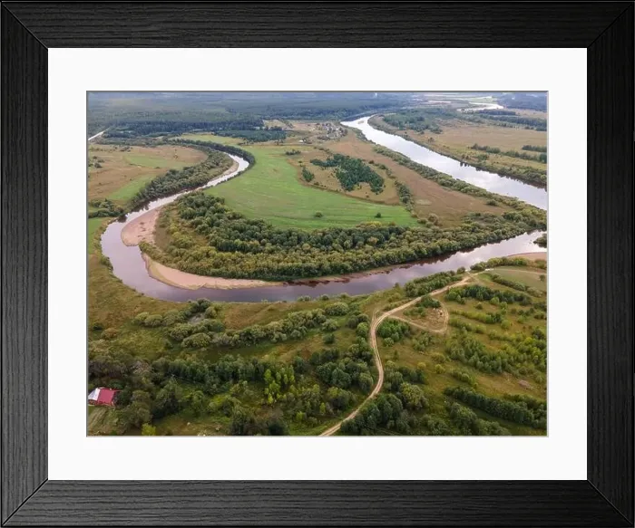 Framed Print : River between wavy road and lawns with trees in countryside Framed Print : River between wavy road and lawns with trees in countryside
