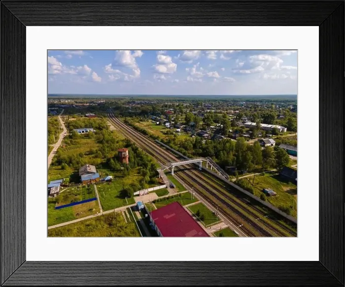 Framed Print : Railroad between trees and houses under cloudy blue sky Framed Print : Railroad between trees and houses under cloudy blue sky