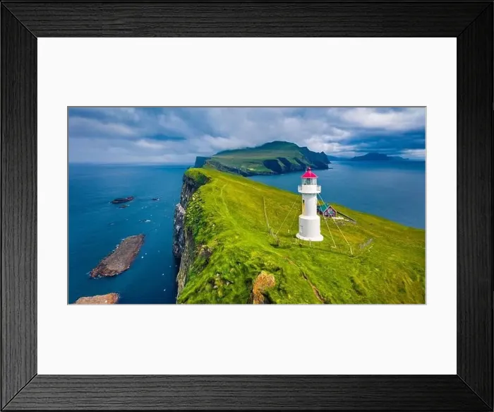 Framed Print : Gloomy view from flying drone of Mykines island with old lighthouse Framed Print : Gloomy view from flying drone of Mykines island with old lighthouse