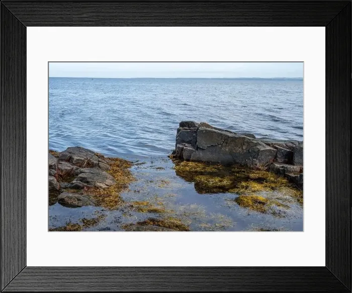 Framed Print : A rocky shoreline with blue water and a blu sky in the background. Picture from Skalderviken, southern Sweden Framed Print : A rocky shoreline with blue water and a blu sky in the background. Picture from Skalderviken, southern Sweden