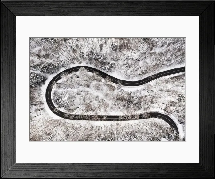 Framed Print : Empty road surrounded by much snow in the winter as a fairytail view from above by drone Framed Print : Empty road surrounded by much snow in the winter as a fairytail view from above by drone