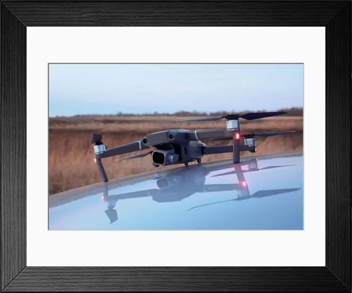Framed Print : A working drone on the hood of a car and its mirror image in the hood with autumn grass in the background Framed Print : A working drone on the hood of a car and its mirror image in the hood with autumn grass in the background