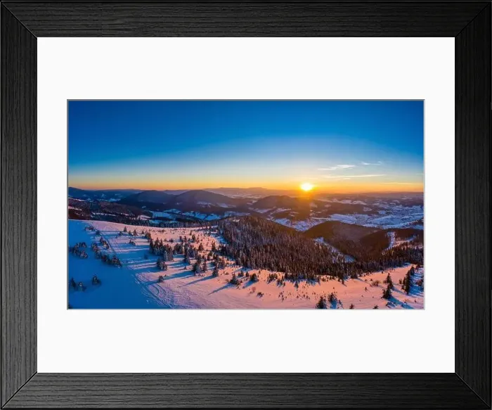 Framed Print : Picturesque winter panorama of mountain hills covered with snow and fir trees on a sunny clear day with the sun