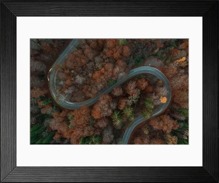 Framed Print : Eycatching drone view at a s-curve in the fall season with light trails of driving cars at the bending road Framed Print : Eycatching drone view at a s-curve in the fall season with light trails of driving cars at the bending road