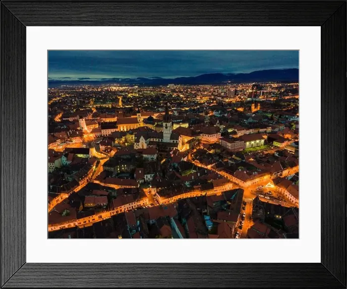 Framed Print : Aerial photography of Sibiu city center shot from a drone at sunset with city lights on. View from above Sibiu, Romania Framed Print : Aerial photography of Sibiu city center shot from a drone at sunset with city lights on. View from above Sibiu, Romania