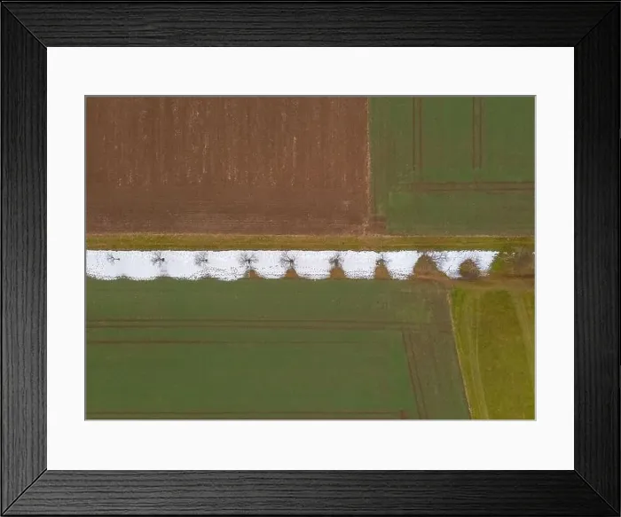 Framed Print : Undecided nature in transition between winter and autumn. A field from above with colors and parts of white snow Framed Print : Undecided nature in transition between winter and autumn. A field from above with colors and parts of white snow