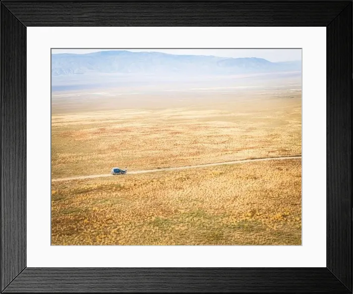 Framed Print : Aerial view of 4WD automobile driving across deserted vast landscape and mountains background VAshlovani national park Framed Print : Aerial view of 4WD automobile driving across deserted vast landscape and mountains background VAshlovani national park