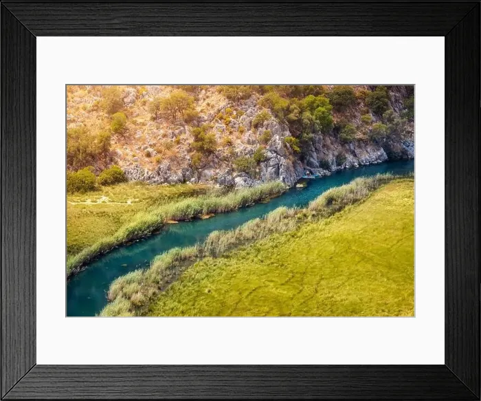 Framed Print : Aerial View of a winding river in the middle of a swampy area with a kayak traveling up the creek Framed Print : Aerial View of a winding river in the middle of a swampy area with a kayak traveling up the creek