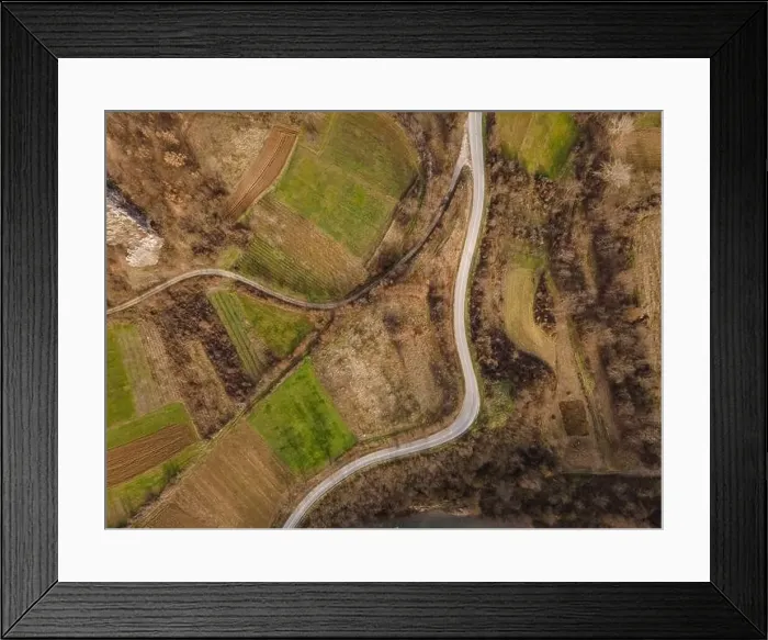 Framed Print : Aerial view top down from above on the country road in mountain range in between fields grass Framed Print : Aerial view top down from above on the country road in mountain range in between fields grass