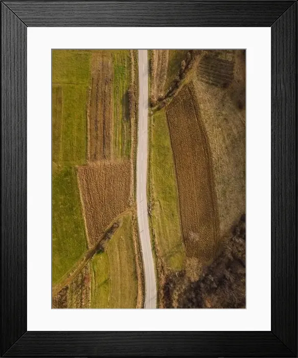 Framed Print : Aerial view top down from above on the country road in mountain range in between fields grass Framed Print : Aerial view top down from above on the country road in mountain range in between fields grass
