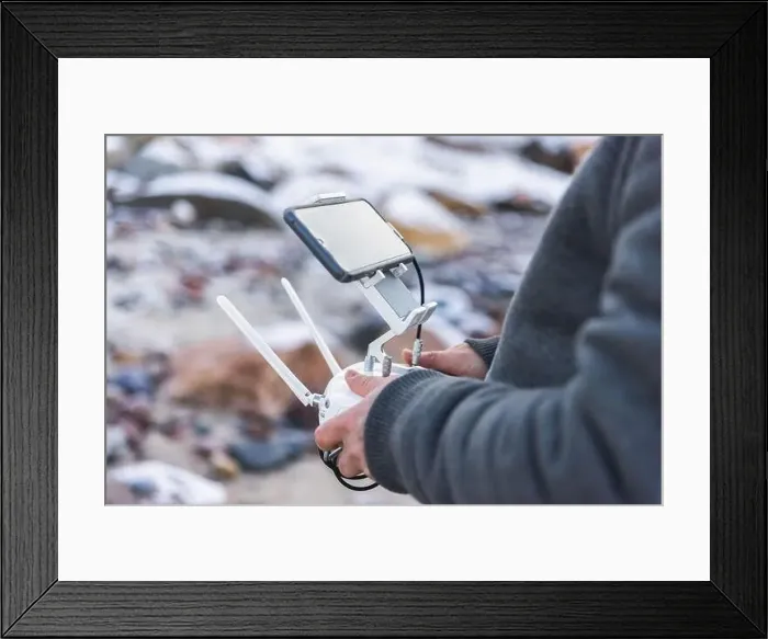 Framed Print : Male hands hold remote control panel of drone for aerial photography with witreless modern technology Framed Print : Male hands hold remote control panel of drone for aerial photography with witreless modern technology