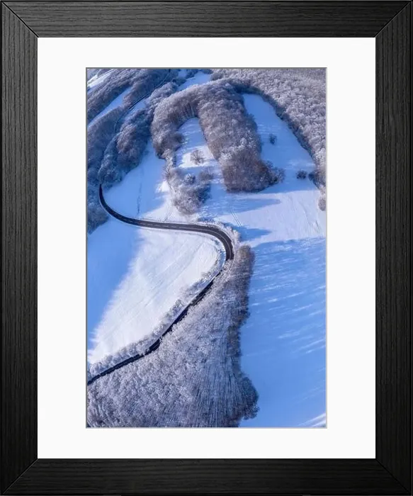Framed Print : Aerial winter landscape. Road leading through snowcapped winter forest Framed Print : Aerial winter landscape. Road leading through snowcapped winter forest