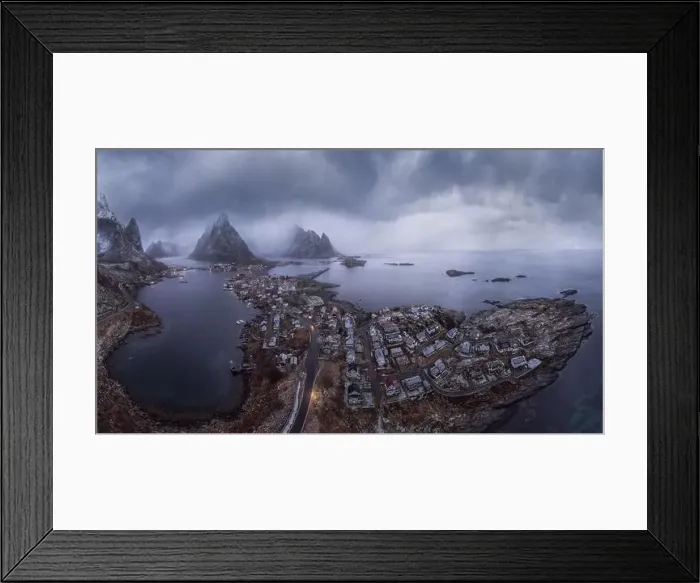 Framed Print : Aerial view of calm water of sea washing island with a village and rocky formations under cloudy sky Framed Print : Aerial view of calm water of sea washing island with a village and rocky formations under cloudy sky