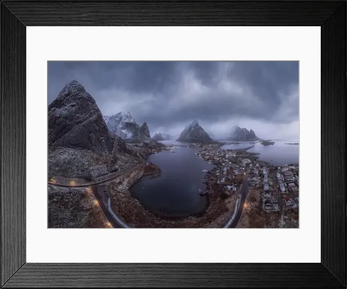 Framed Print : Aerial view of calm water of sea washing island with a village and rocky formations under cloudy sky Framed Print : Aerial view of calm water of sea washing island with a village and rocky formations under cloudy sky