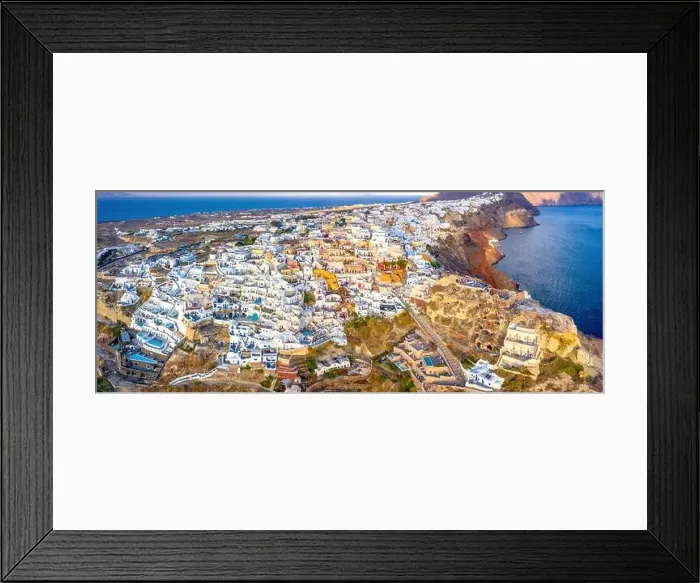 Framed Print : Picturesque Aerial drone view of famous Oia village with white houses during sunrise on Santorini island Framed Print : Picturesque Aerial drone view of famous Oia village with white houses during sunrise on Santorini island