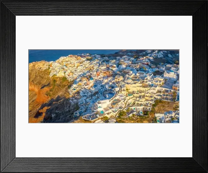 Framed Print : Picturesque Aerial drone view of famous Oia village with white houses during sunrise on Santorini island Framed Print : Picturesque Aerial drone view of famous Oia village with white houses during sunrise on Santorini island