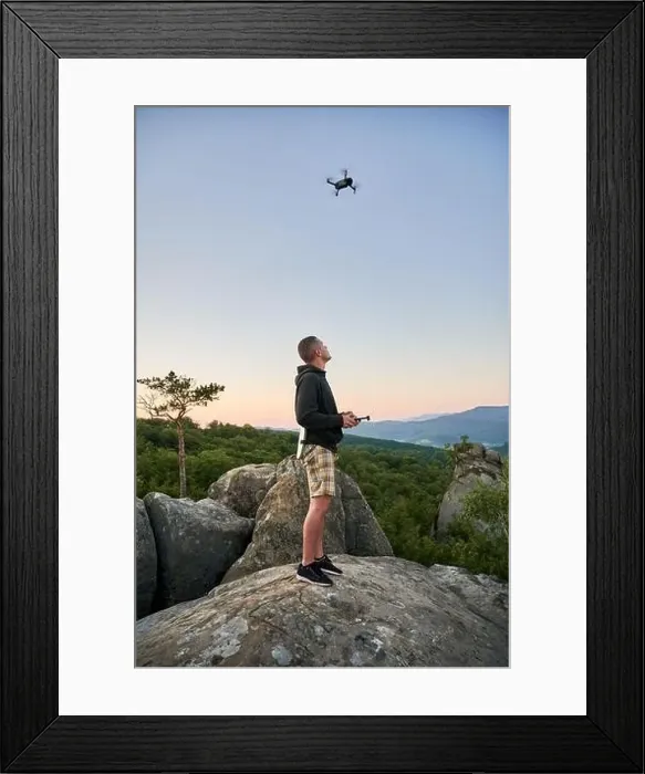 Framed Print : Man operating drone using remote controller