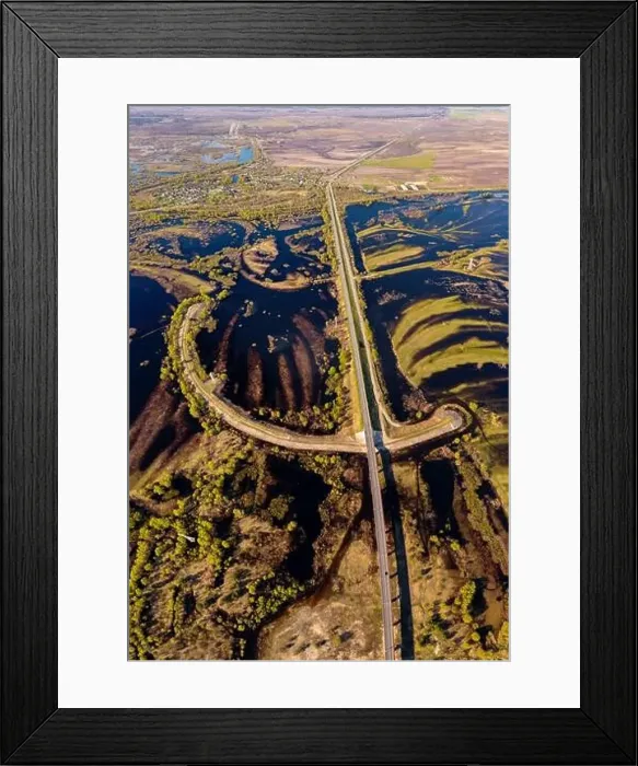 Framed Print : Road through flooded meadows in spring from above. Floodplains of river Pripyat shot from a drone Framed Print : Road through flooded meadows in spring from above. Floodplains of river Pripyat shot from a drone